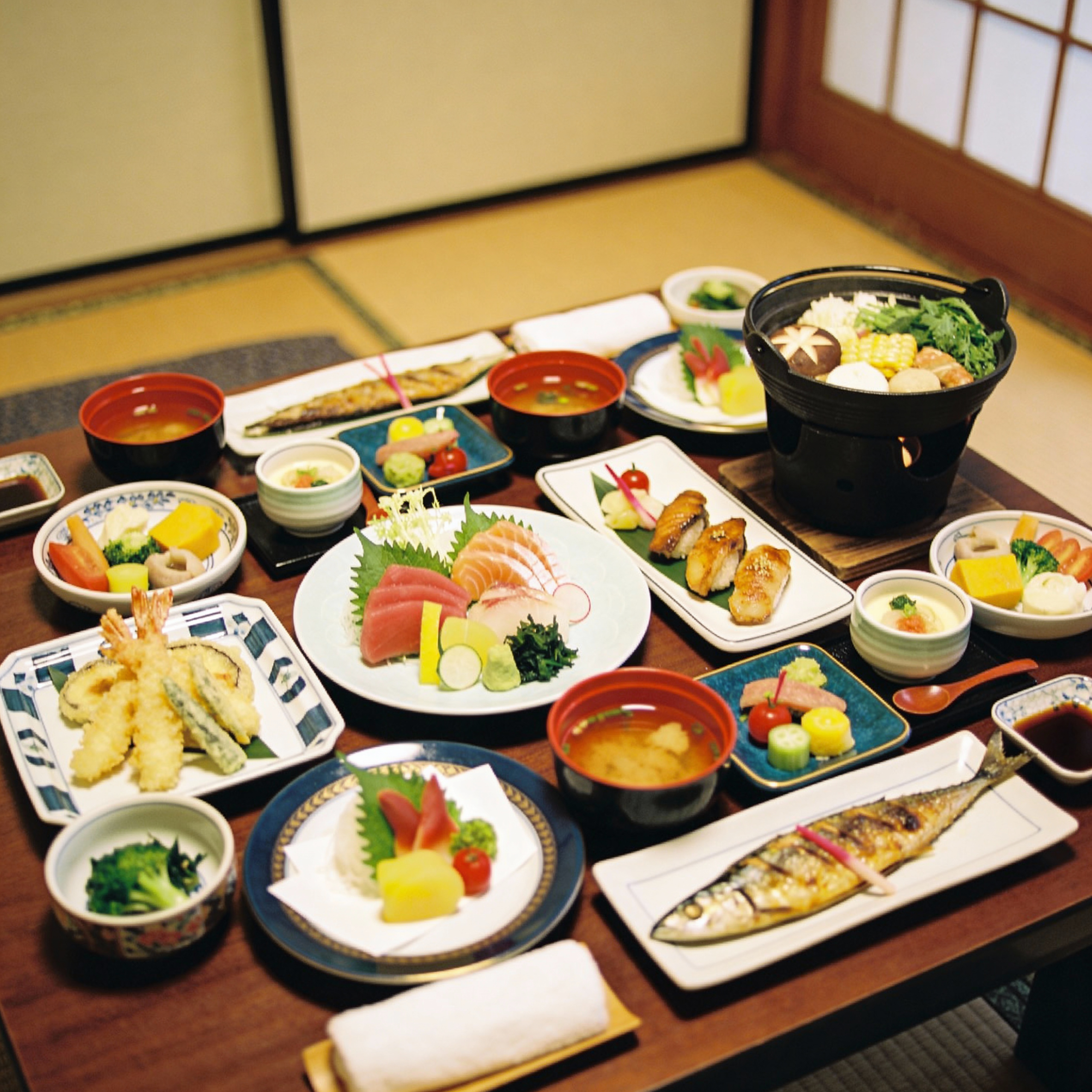 A top-down food photography shot of a lavish Japanese Kaiseki dinner feast spread out on a wooden table in a Ryokan room. Numerous small, artfully plated dishes including sashimi, grilled fish, tempura, a small hot pot, and seasonal vegetables. Colorful, intricate, and abundant.